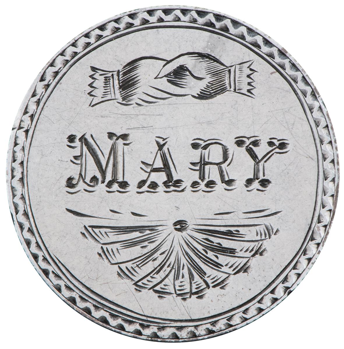 Coin, silver, smoothed, the word Mary, hands clasping and a fan design engraved on it.