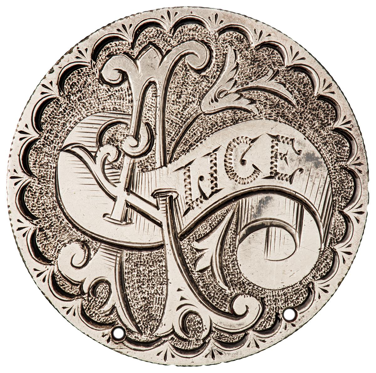 Coin, silver, smoothed with a deep and elaborate engraving of the name Alice.