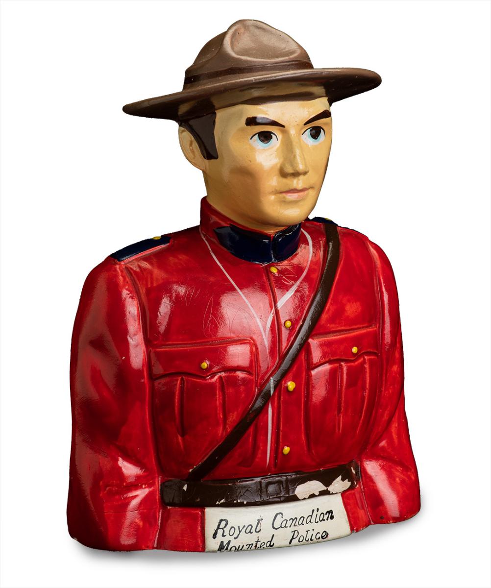 Model of RCMP policeman in a red jacket and a broad-brimmed hat.