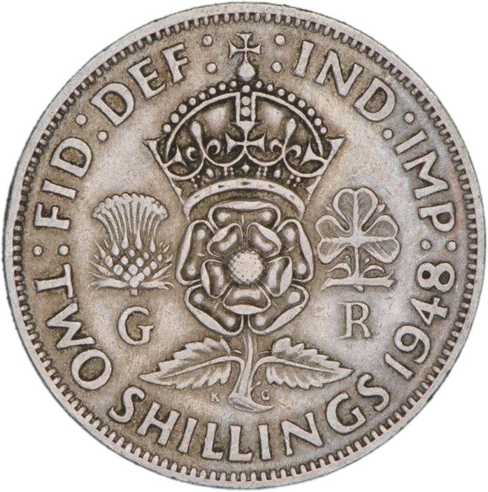 Silver coin with a crown over an English rose, Scottish thistle and Irish clover leaf.