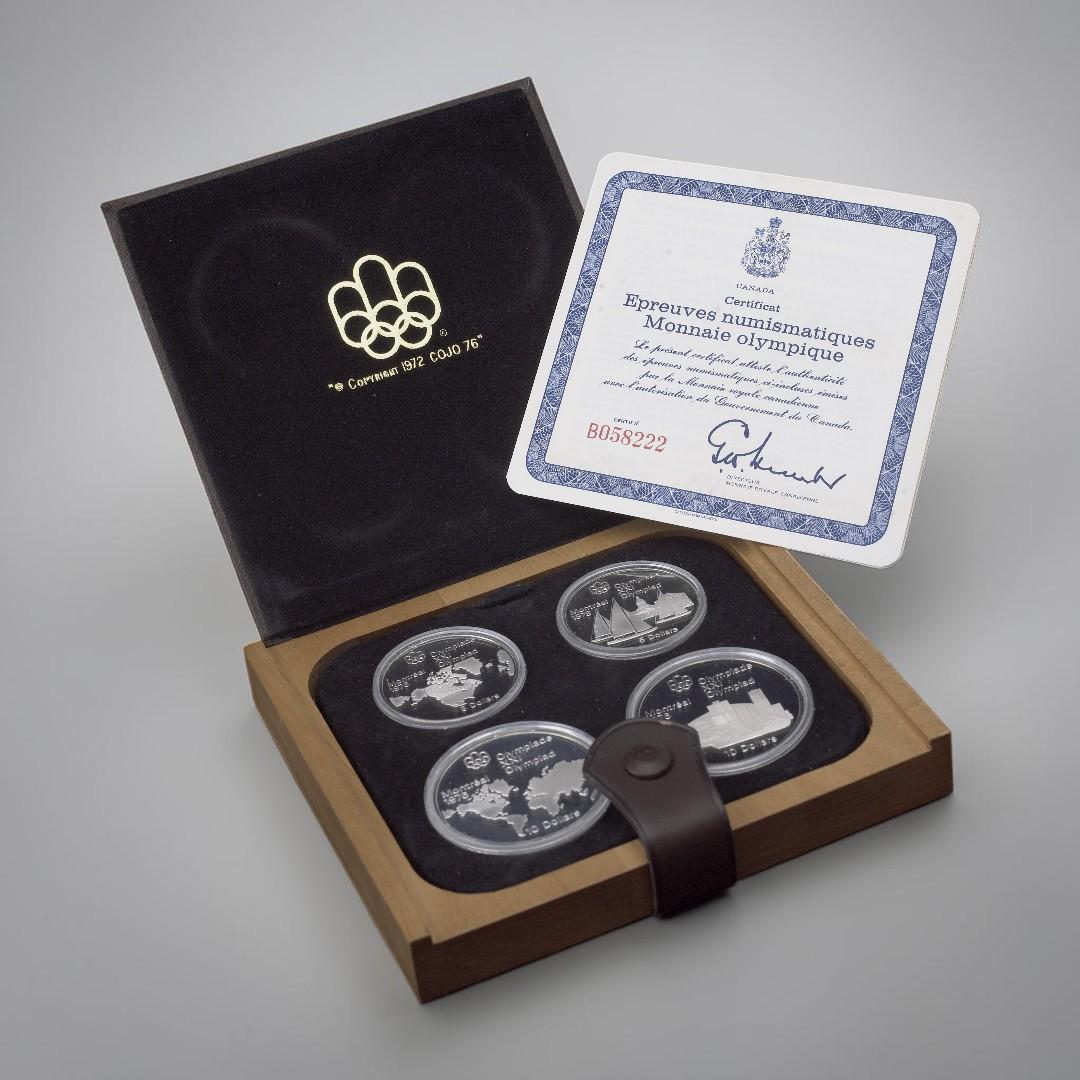 Leather case, square, flat, holding four silver coins all alongside a certificate.