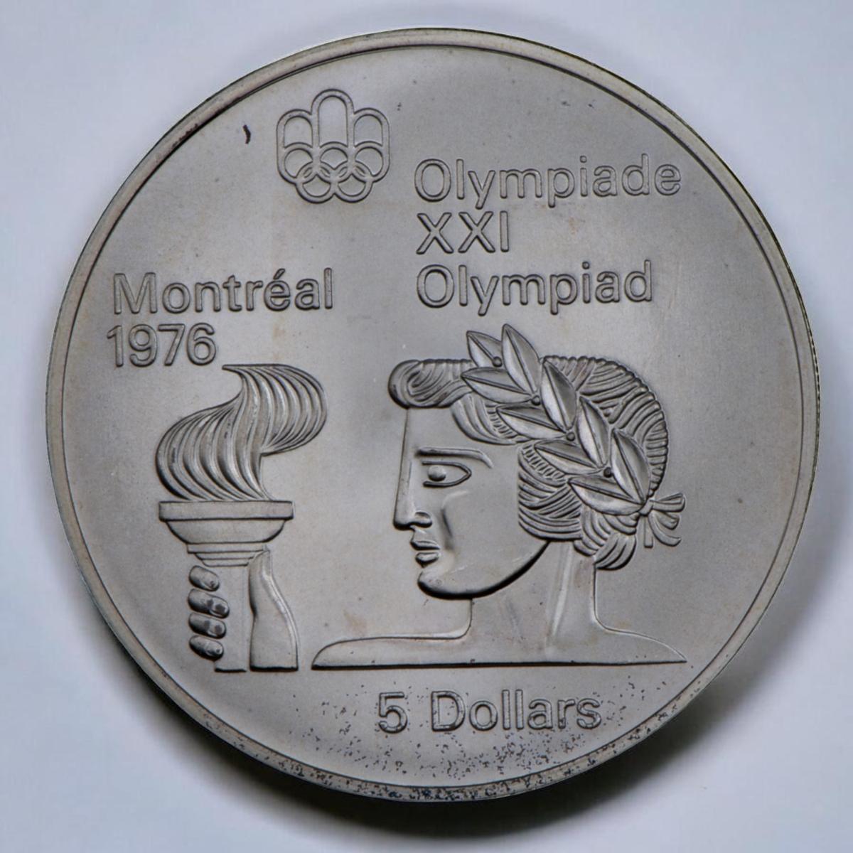 Coin, silver, person’s head in profile, leaves in hair, hand holding a torch before face.