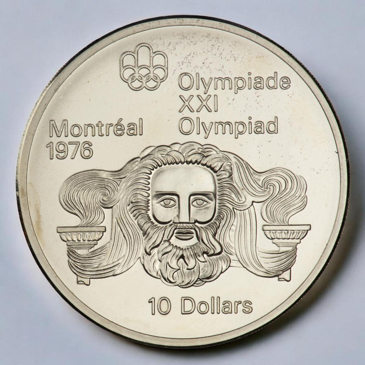 Coin, silver, bearded face with long hair growing from the flames of torches on either side of his face.