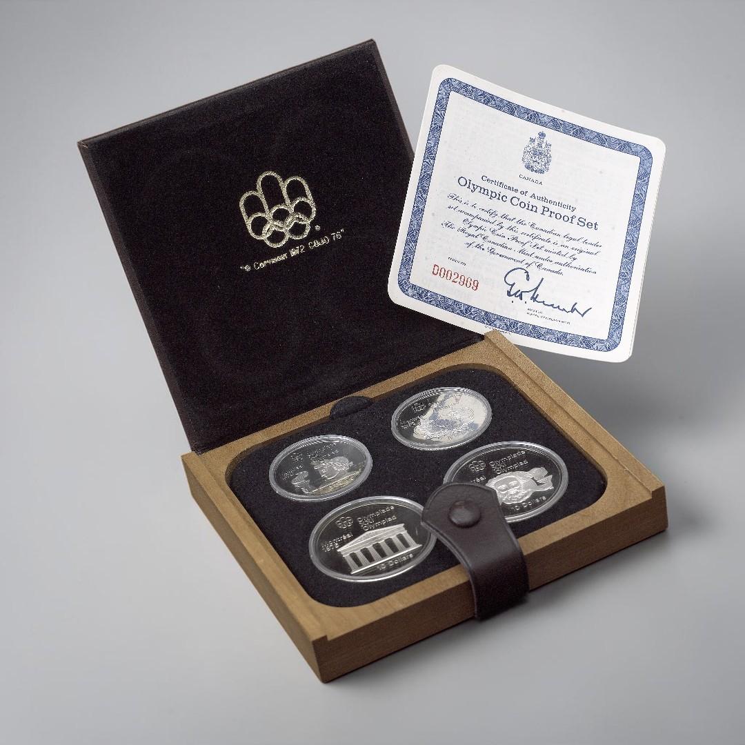 Leather case, square, flat, holding four silver coins all alongside a certificate.