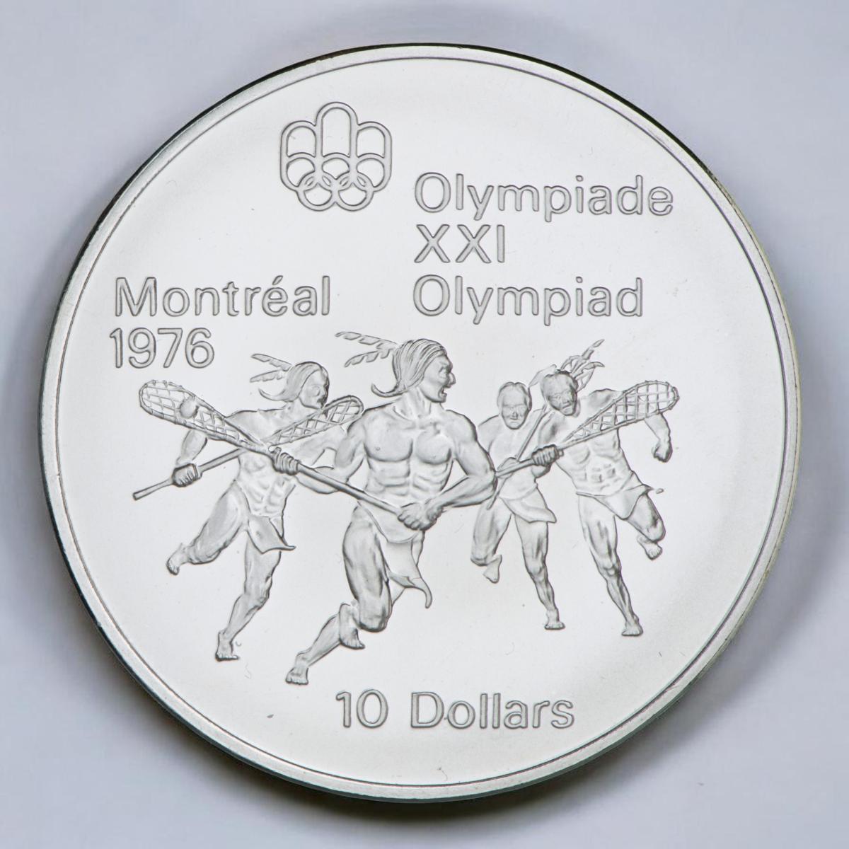 Coin, silver, muscular Indigenous men running in field all carrying sticks with nets attached to the ends.