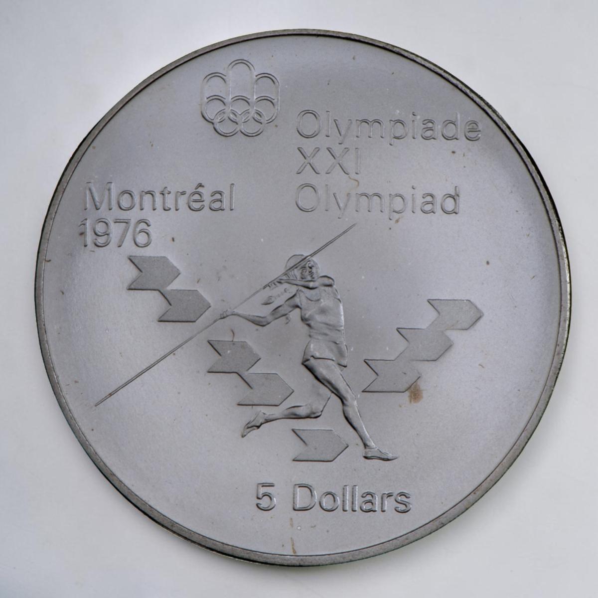 Coin, silver, female athlete running and throwing a long rod, surrounded by arrow motifs.