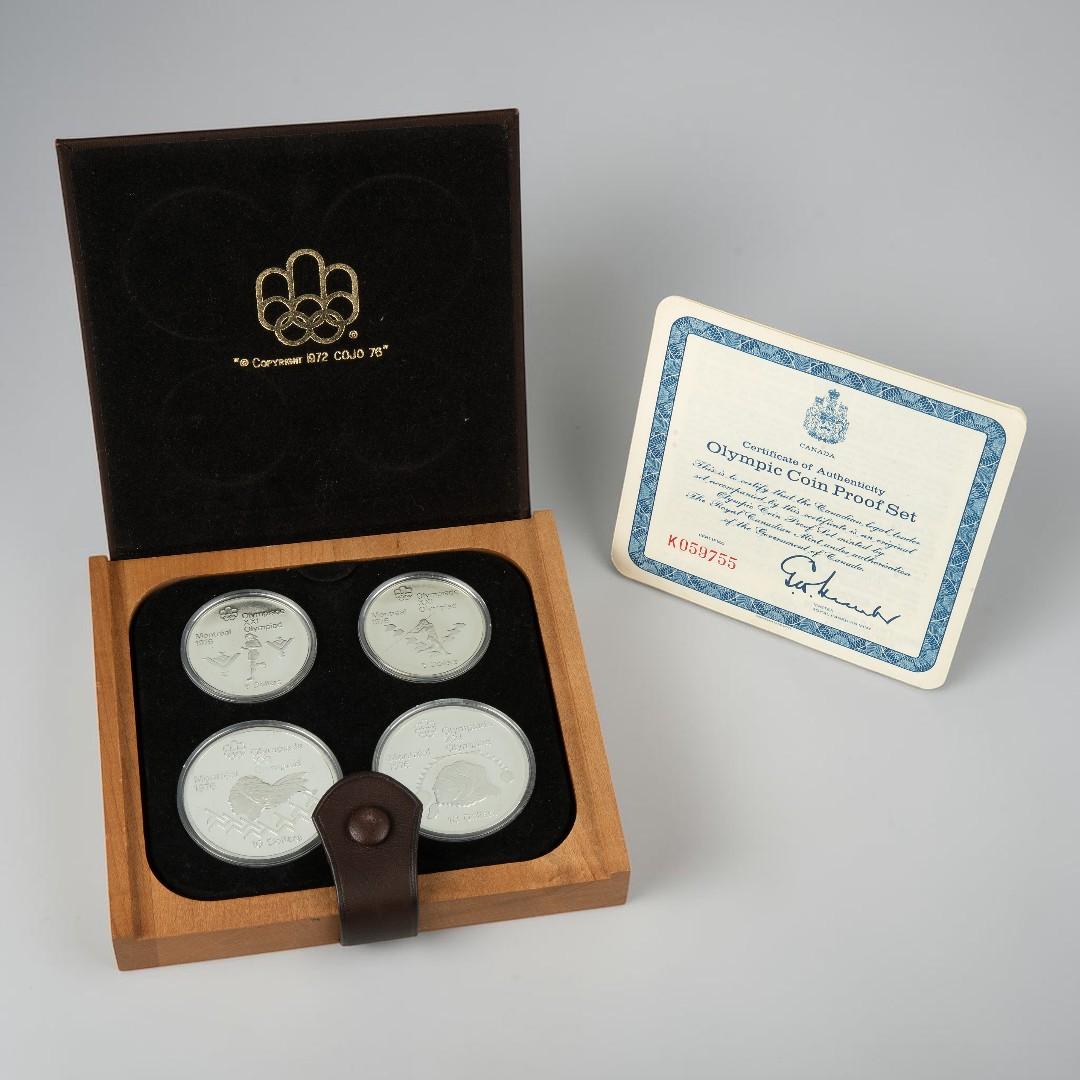Leather case, square, flat, holding four silver coins all alongside a certificate.