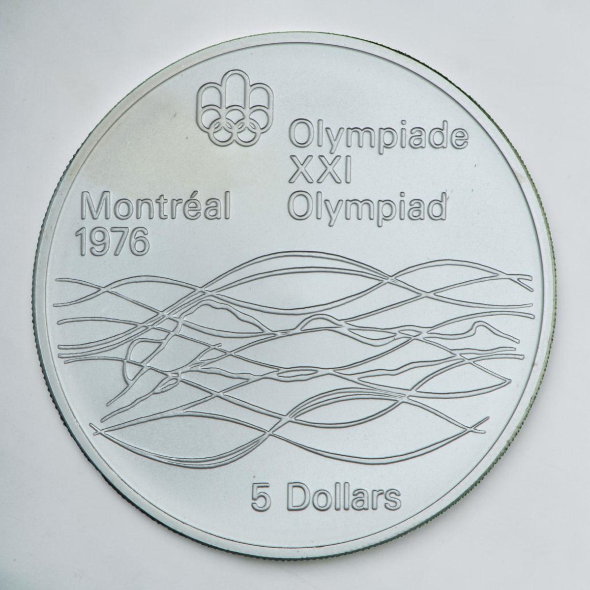 Coin silver, stylized outline of a swimmer, horizontal with arms above head amid wavy lines.