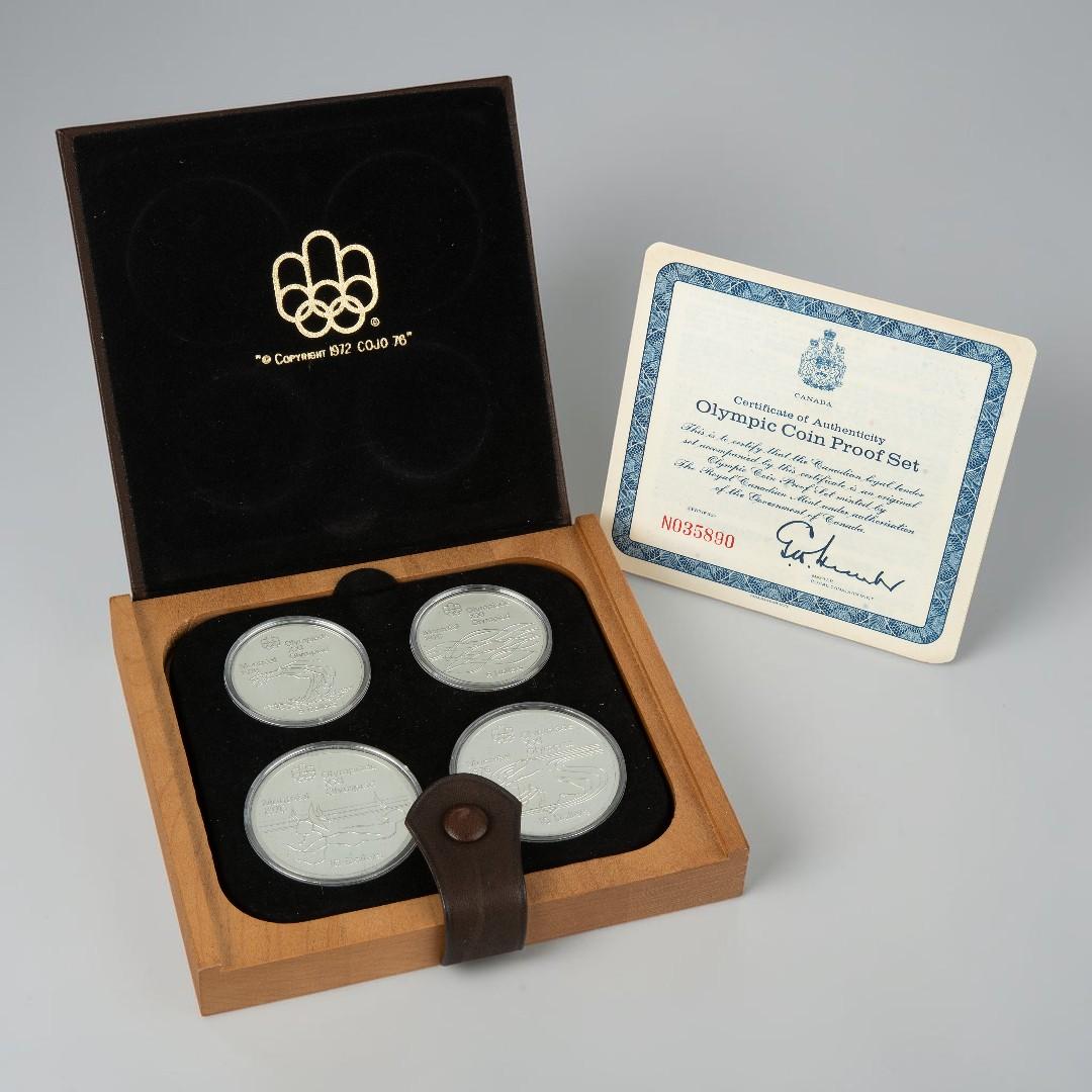 Leather case, square, flat, holding four silver coins all alongside a certificate.