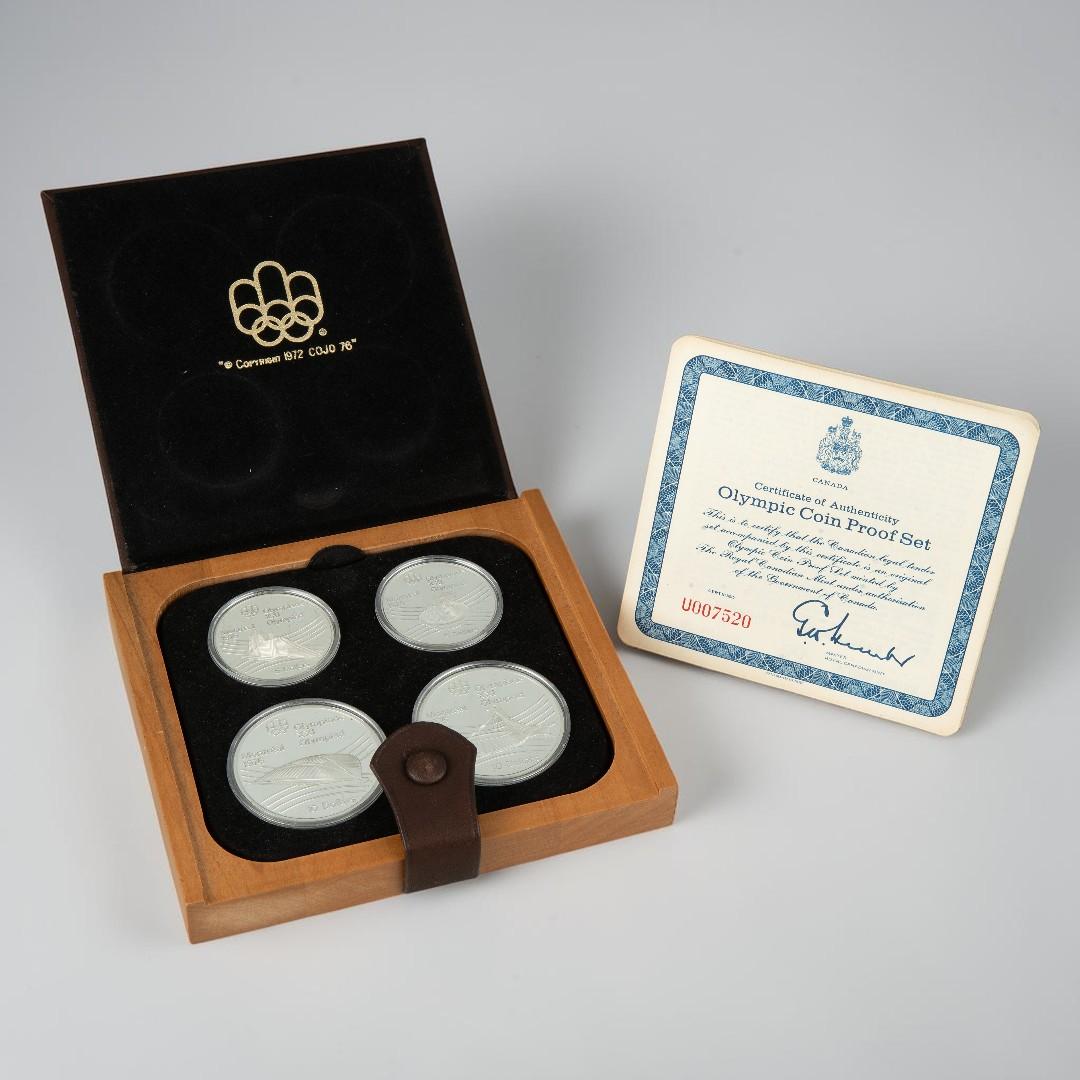 Leather case, square, flat, holding four silver coins all alongside a certificate.
