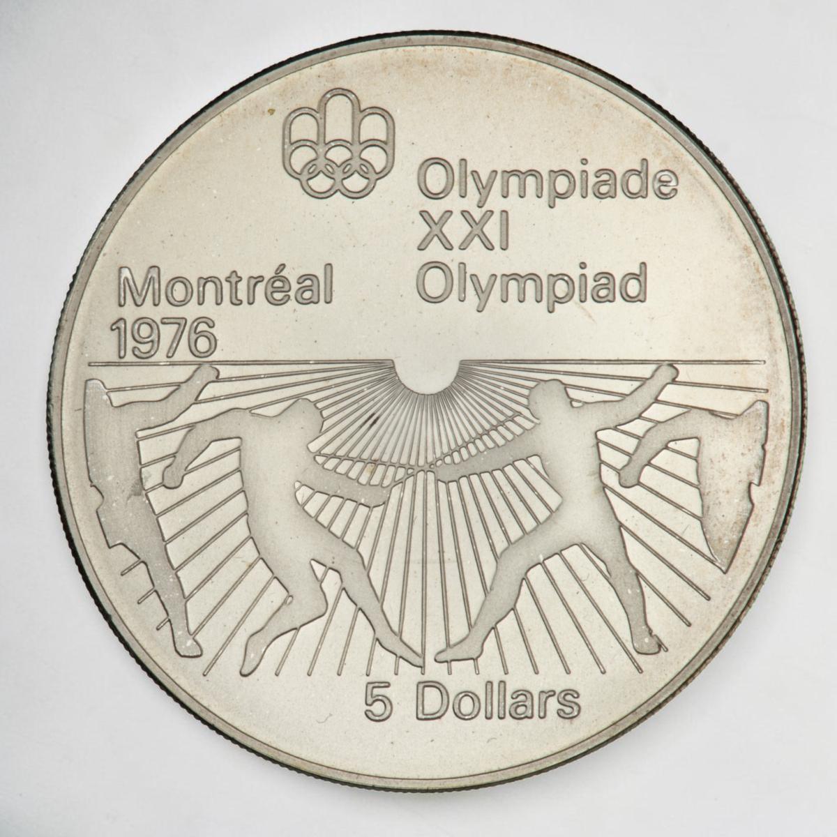 Coin, silver, sunburst pattern on bottom half with outlines of 2 people crossing short rods while holding an arm in the air.