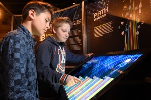 two boys manipulating a digital touch panel