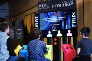 a group of kids sitting in front of a large digital display panel