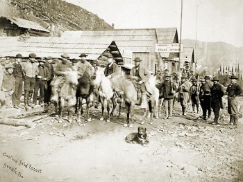 horses in front of wooden buildings