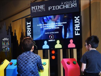 kids sitting at a game kiosk