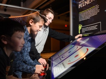 three boys at a video game terminal