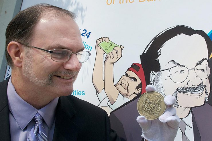 Paul Berry with coin and cartoon