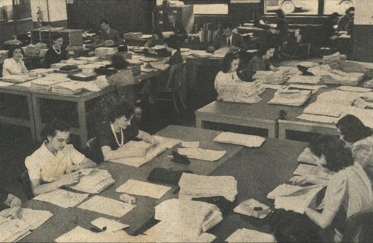 newspaper image of dozens of women working in an open office