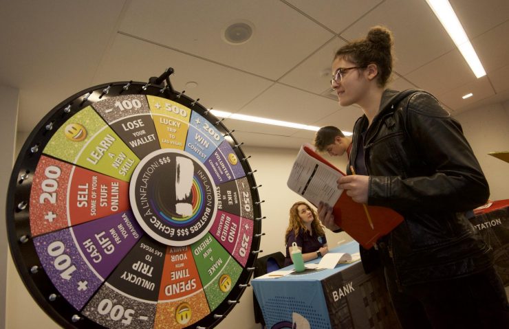a student spins the wheel of chance in the school program Inflation Busters a student spins the wheel of chance in the school program Inflation Busters