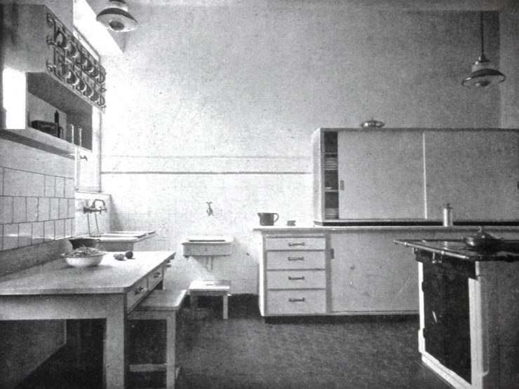 Black and white photo of a very basic kitchen.