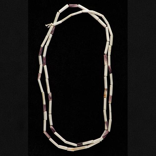 Wampum bead string with long, cylindrical shell beads in beige and light purple or brown. Looks like a necklace.