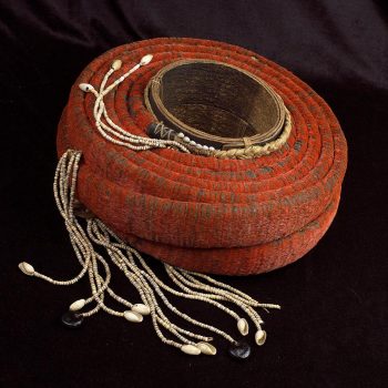 A length of narrow, red fabric coiled around a cylinder.