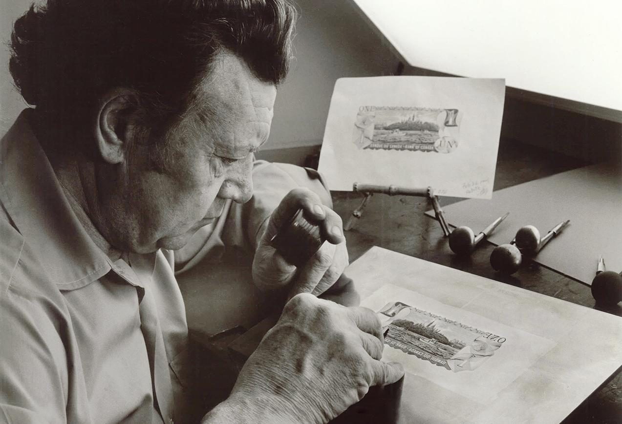 Photo, man holding a magnifying glass and engraving onto a steel plate an image of logs floating on a river.