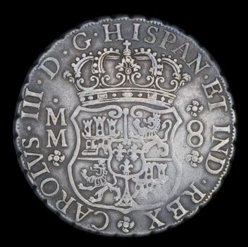 Silver coin of 8 reales, obverse side showing coat of arms of Spain crown and Latin script.