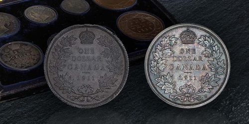 In front of a set of coins in a case, two coins, one lead, one silver, each with identical wreaths of maple leaves.