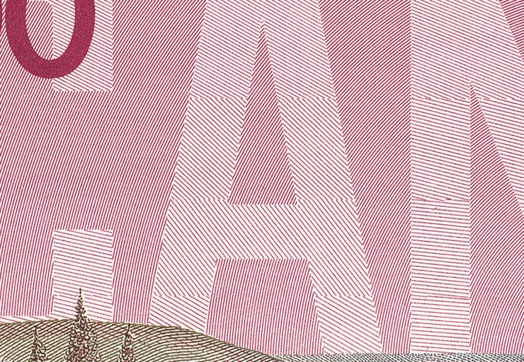 Bank note, close-up, block letters without outlines and made up of tiny parallel lines.