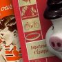 Collage, ceramic pig on background of a bank book and a stamp folder with kids on it.