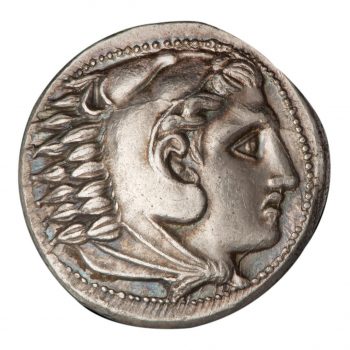 Coin, silver colour, roughly round, head of a man in a helmet with feathers.