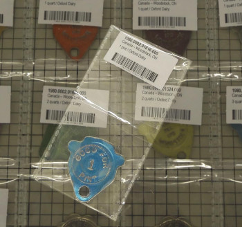 A metal token in a clear plastic sleeve with two pockets.