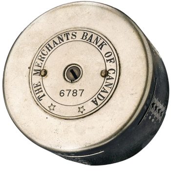 Cylinder, steel, top with a key slot and serial number, inscribed with a bank’s name.