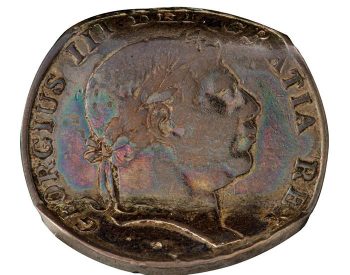 Coin, brown, profile of a man with laurel leaves in his hair, the top bent away and the bottom bent toward the viewer.