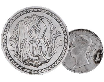 Coin, silver, smoothed flat, extremely elaborate and stylized initials interlaced with one another, the back showing a young woman with hair tied up.