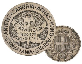 Coin, smoothed flat, maple leaf, words and patterns made up of tiny dimples, a crowned shield with a cross on the back.