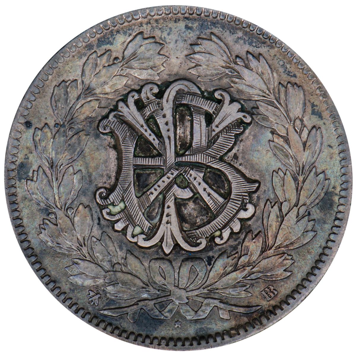 Silver coin, smoothed, re-engraved with initials interlocked and stacked on each other and surrounded by a wreath of leaves.