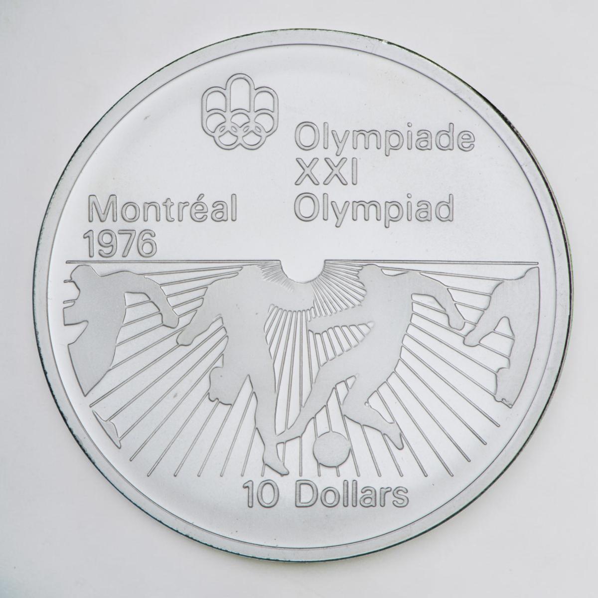 Coin, silver, sunburst pattern on bottom half with outlines of figures kicking and trying to gain control of a ball.