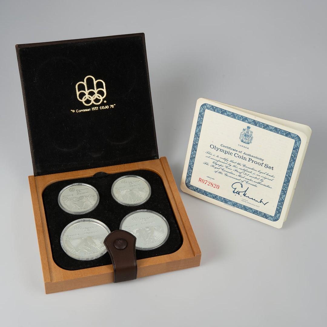 Leather case, square, flat, holding four silver coins all alongside a certificate.