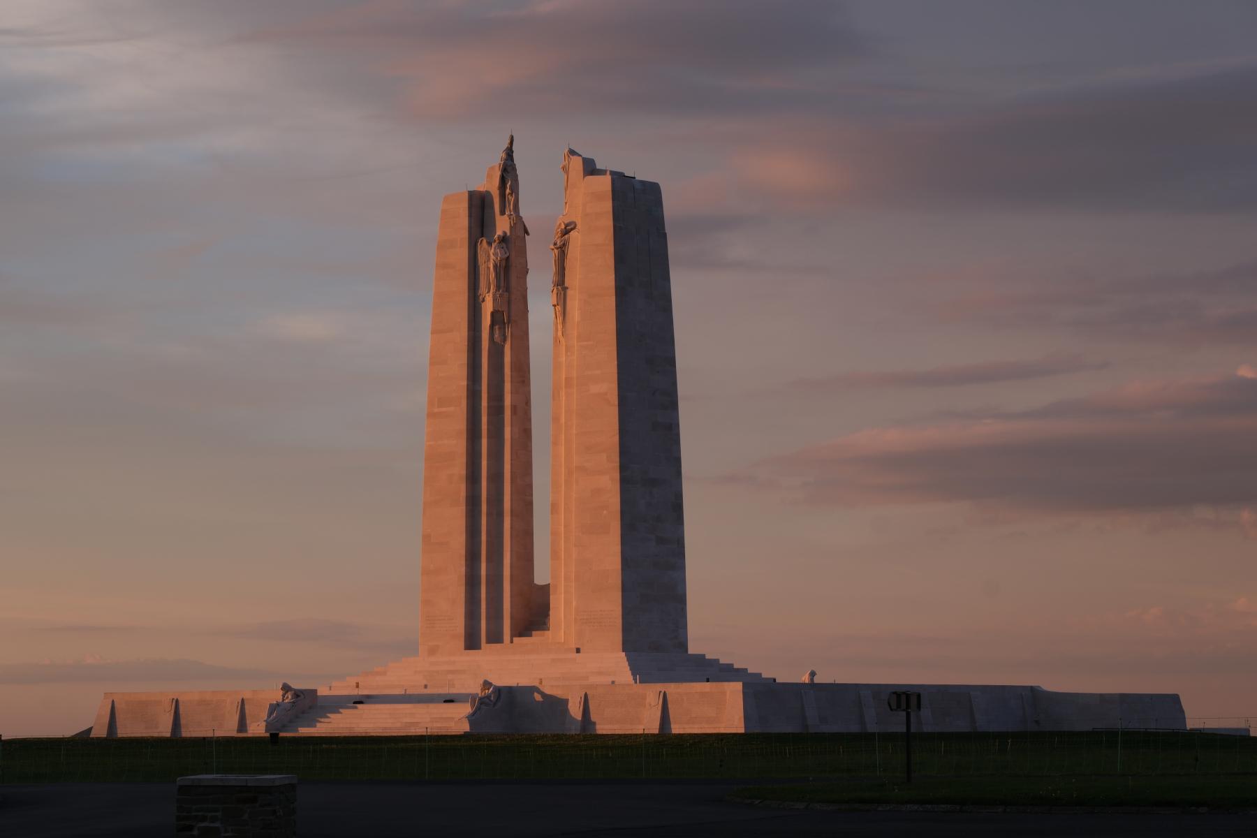 Vimy Memorial A photo of the Canadian National Vimy Memorial, a large stone monument with two tall pillars on a grassy hill, at sunset.